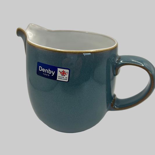 Blue ceramic mug with a visible brand label on a white background